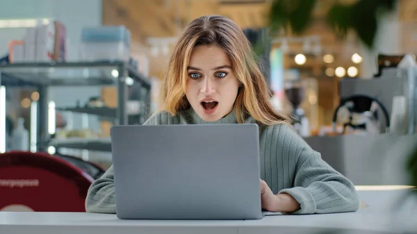 Portrait beautiful young girl student business woman female user winner looking into laptop surprised wide open mouth with delight good news applauds happiness winning opportunity new job notification — стоковое фото