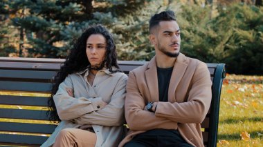 Parkta bankta oturan asık suratlı bir çift kollarını kavuşturmuş sevgilileriyle oturup tartışıyor kızgın Arap erkeği görmezden geliyor ve kıvırcık bir kız anlaşmazlık yanlış anlaşılmasından dolayı üzgün hissediyor.