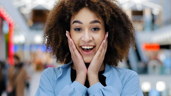 Retrato femenino en el interior primer plano felicidad africano americano rizado chica sosteniendo la cara con las manos de la sorpresa ganando alegría sorprendido inesperada noticia de la victoria suerte nuevo trabajo recibe oferta sorprendida — Foto de Stock