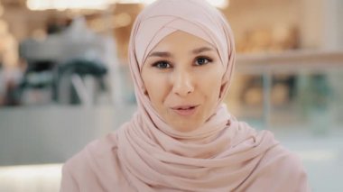 Webcam view young arab muslim woman in hijab speaks looking at camera smiling girl talking on cam job interview female entrepreneur explaining terms of contract by videoconference online presentation