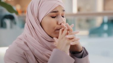 Close-up upset young woman gets bad news feels stressful anxiety frustrated muslim girl suffers from headache grabs head with hands migraine unresolved problems feeling sorrow grief divorce job loss