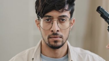 Erkek portresi yakın plan Arap sakallı adam gözlüklü adam kameraya bakıyor tapınağın yakınında silah tutuyor intihar sorunları çekerken zihinsel sorunlar yaşıyor