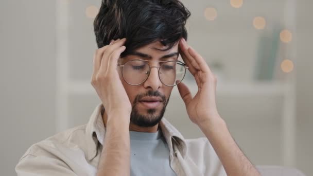 Zbliżenie arabski człowiek brodaty facet w okulary czuje stres przepracowanie ciśnienie czaszki masaże waga na głowie cierpi na ból głowy migrena wzdychając ciężko choroba uczucie złe atak paniki problem — Wideo stockowe