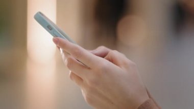 Yakın plan yan görüş genç kadın ellerinde telefoncu kız var. Çağdaş aygıtlara mesaj yazıyor. Uzaktan iletişim uygulaması kullanarak online alışverişleri internet mesafesinde sohbet ederek kablosuz teknoloji kavramına dönüştürüyor.