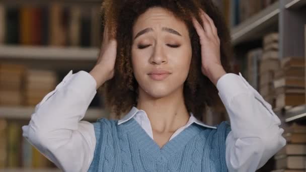 Zblízka smutná frustrovaná mladá žena trpící hlasitým zvukem zakrývající uši s rukama držícíma hlavu hispánská dívka student stojí v knihovně pocit znechucení odmítá poslouchat drby konverzace — Stock video