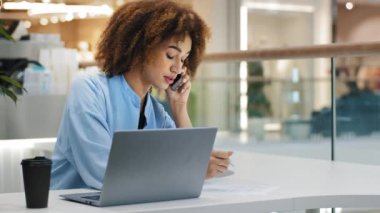 Afrikalı Amerikalı meşgul iş kadını serbest çalışan kız menajer kız patron kadın lider cep telefonuyla konuşan arama cevaplama notları yazan online laptop pazarlıkları çoklu görev kavramı
