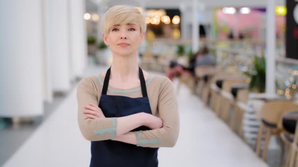 Mature adult middle aged 40s woman lady restaurant cafe worker looking at camera posing crossing arms female waitress saleswoman in apron standing at work space profession concept. Small business — Stock Video