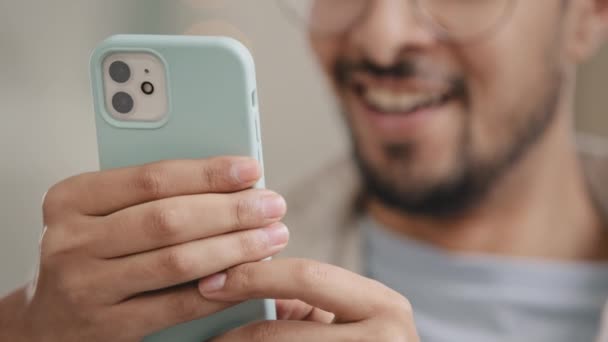 Close-up de mãos masculinas com smartphone dentro de casa. Homem irreconhecível usando telefone trabalhando estudando e mensagens de texto com telefone celular em casa digitando mensagem de texto no telefone celular navegando usando o gadget do aplicativo — Vídeo de Stock