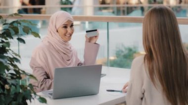Müslüman mali danışman bankacı kredi kartı veriyor tanınmayan kız müşteri banka kredisinin onaylanması için sözleşme imzalıyor ipotekli Arap yönetici temassız ödemenin faydalarından bahsediyor