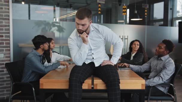 Zamyšlený mladý muž odvrací pohled od stolu v kanceláři seriózní muž přemýšlí o řešení problému podnikatel dělá obtížné rozhodnutí vzhledem k nápadu projektu multiraciální spolupracovníci sedět na setkání — Stock video