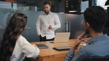 Öfkeli ciddi lider, ofiste çok ırklı grup arkadaşlarıyla buluşup yeni proje patronunun şirket geliştirme stratejisi yanlış anlama kavramını çalışan çalışanlarla tartıştığını savunuyor.