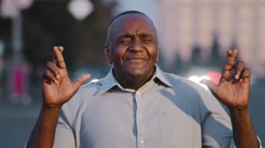 Umut dolu yaşlı Amerikalı erkek girişimci şans diliyor açık havada dilekler diliyor, insan kıdemli işadamı umutsuz batıl inançlı insan jest umutlarını iyi şansa inandırıyor.