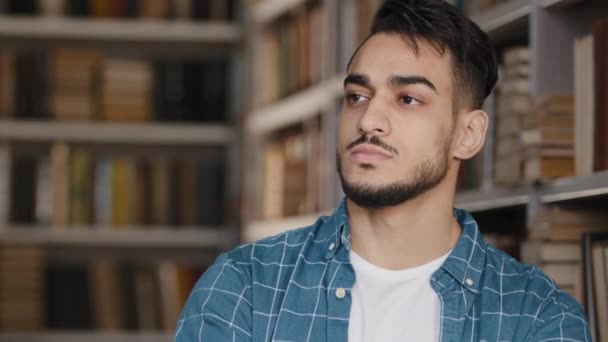 Bedachtzame ernstige bezorgd jonge Spaanse mannelijke student staan in de openbare universiteitsbibliotheek denken over de toekomst examens nieuwe ideeën kansen op zoek naar kant houden kin dromen ondergedompeld gedachten — Stockvideo
