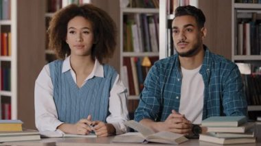 İki öğrenci derste sınıfta masasında oturup ders seminerlerini dinliyorlar. Not defterine bilgi yazıyorlar. Kızları tartışıyorlar, erkeklerin yüksekokul konseptini öğrenmelerine yardımcı oluyorlar.