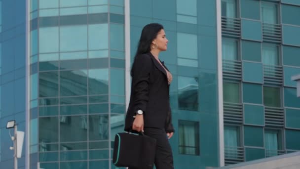 Stressed young businesswoman walks anxiously waiting for meeting waits for taxi with annoyance looks at time on wrist watch nervous angry wait for interview worried about being late lateness concept — Stock Video