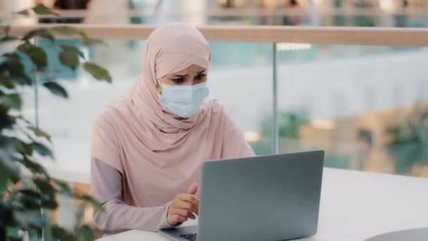 Mladý arab žena v hidžábu nosí ochranné masky čtení e-mail na notebooku obdrží špatné zprávy dívka rozrušená oznámením propuštění z práce finanční krize zdravotní problémy selhávají zkouška rozvodu — Stock video