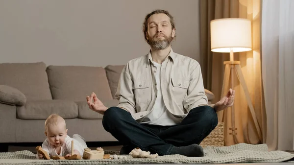 Vousatý otec táta muž rodič sedí na podlaze v lotosu pozice meditování stresu meditace zbytek malá dcera dítě dítě dívka hrát s hračkami v blízkosti tatínek asana duchovní praxe — Stock fotografie