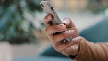 Yakından erkek eli tanınmayan bir adam elinde telefonla haberleri okuyan genç bir adam ücretsiz cep telefonu uygulaması ile sosyal ağdan akıllı telefon internet sörfü satın alarak bilgi yazıyor.