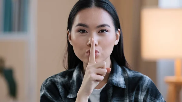 Portré ázsiai etnikai koreai nő ujjal a száj közelében kínai japán lány teszi csendes gesztus mutató titkos jel kéri csendes bizalmas titoktartási információt nézi a kamera beltéri — Stock Fotó