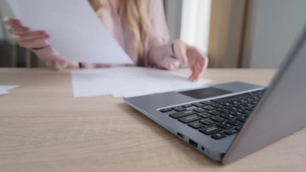 Detailní záběr ženské ruce s dokumenty třídění dokumentů psaní na notebook u stolu v kanceláři. Nerozpoznatelný kavkazský obchod žena učitelka papírování na domácí účty platby kontakty s počítačem zaneprázdněn — Stock video