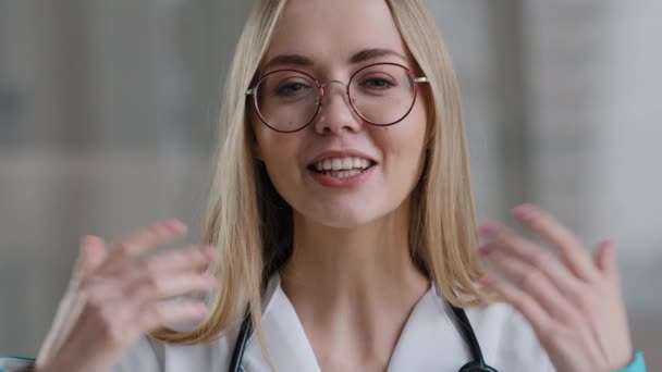 Blanke vrouwelijke arts dragen bril maken online video bellen in ziekenhuis kliniek raadpleeg patiënt verre gesprek. Medische assistent therapeut vrouw internet conferentie. Webcameraweergave — Stockvideo