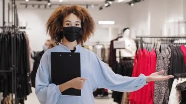 Kara Cuma. Afro-amerikan kadın satış danışmanı butik mağazası çalışanı alışveriş merkezinde duruyor indirimli kıyafet almak için davet ediyor indirimli satış davetiyesi