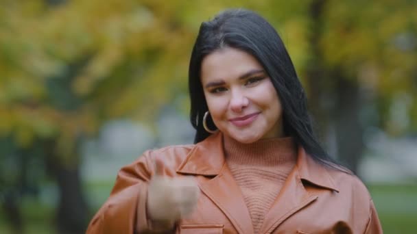 Close-up jonge vrolijke Spaanse vrouw buiten staan glimlachen wit gezonde tanden glimlach kijkt naar de camera met duimen omhoog gebaar goedkeuring overeenkomst symbool goed cijfer tevreden met de tandheelkundige dienst — Stockvideo