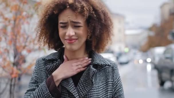 Portrait afro-américain souffrant d'amygdalite angine debout à l'extérieur portrait femme malsaine toucher le cou se sent mal à l'aise sentiments douloureux difficile à avaler mal douleur mal de gorge mal de voix perdu — Video