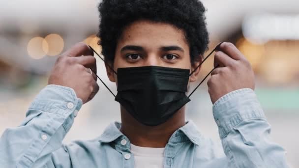 Retrato masculino rosto mascarado afro-americano cara homem decolando máscara médica sorrindo olhando para o alívio da câmera final de coronavírus terminar recuperação pandêmica de doença vívida vírus vitória respiração livre — Vídeo de Stock