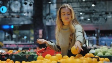 Markette alışveriş sepeti olan beyaz kadın tüketici. Portakal sulu narenciye. Lezzetli meyve, indirimler, diyet, sağlıklı yeme konsepti.