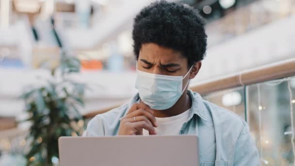 Portrait afro-américain gars étudiant utilisateur homme d'affaires dans le plan de pensée masque médical crée une stratégie d'idée de travail avec ordinateur portable réfléchi à résoudre le problème avec l'application informatique pense — Video