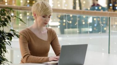 Orta yaşlı, iş kadını, avukat, dizüstü bilgisayarı olan 40 'lı yaşlarda, sohbet danışmanlığı yapan, online, profesyonel, bilgisayar uygulaması kullanan kadın yazarlar çalışma masasında oturuyor.