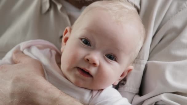 Retrato pequena menina bonito menino pequeno recém-nascido de olhos azuis criança olhando para a câmera. Homem-pai irreconhecível a abanar embalos a segurar o filho-filha. Conceito de custódia de adopção. Pediatria creche — Vídeo de Stock