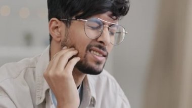 Yakın plan, gözlüklü hasta Hintli erkek üzgün, İspanyol sakallı diş ağrısı çeken adam. Portre çizen adam diş ağrısı çekiyor. Diş eti taşıma ve ağız sorunu konseptiyle kontrol ediliyor.
