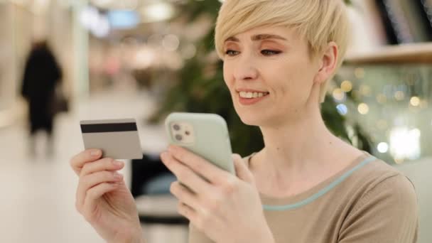 白种人中年成年商业女性购物者消费者女士带着手机和信用卡，用支付应用程序支付商品在线汇款到互联网账户的订单 — 图库视频影像