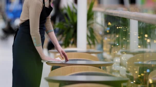 不知名的女性咖啡店女服务员在围裙下穿着特殊的衣服擦拭擦拭桌子擦去污渍准备开始工作日处理表面的细菌 — 图库视频影像