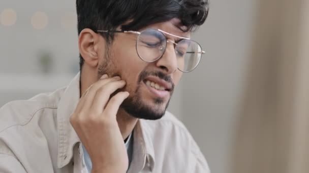 Gros plan malade indien homme à lunettes mâle triste hispanique arabe homme barbu souffrant de douleur dentaire. Portrait guy se sent mal à l'aise dans la gencive caries holdong vérifier avec la main dentaire problème buccodentaire concept — Video