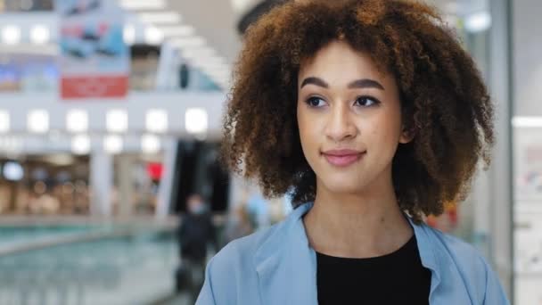 Retrato chica relajada afroamericana mujer de 20 años con el pelo rizado elegante peinado mujer de negocios gerente beber té de café de la taza de papel desechable disfrutando del fin de semana de descanso de trabajo en el centro comercial — Vídeos de Stock