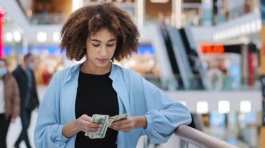 Milenyum Afrikalı Amerikalı tüketici kız tüketici müşteri kadın alışveriş merkezinde duruyor nakit para sayıyor para kazanıyorlar para kazanıyorlar maaş kazanıyorlar çek kazanıyorlar indirim yapıyorlar