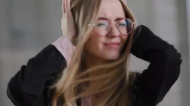 Kafkasyalı, yorgun, üzgün, gözlüklü, üzgün, üzgün, gözlüklü, iş kadınını strese sokan, kulakları kulaklarıyla kapatan, dinlemeyi reddeden, anlaşmazlık, stres, stres, üzüntü sorunları olmayan, başı titreyen bir kadın.