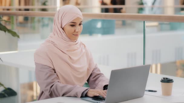 Feliz joven árabe mujer de negocios sentado en el escritorio de la oficina escribiendo en el ordenador portátil que trabaja en Internet comprobar la nueva aplicación sonriendo mirando a la cámara que muestra el pulgar hacia arriba aprobación signo de consentimiento símbolo de apoyo de alta calificación — Vídeos de Stock