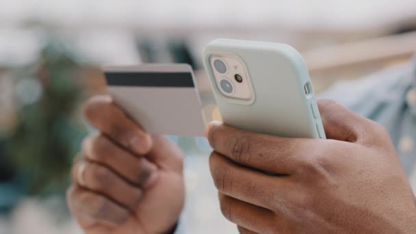 온라인상에서 휴대 전화와 은행 카드 쇼핑을 하는 근접 한 남성 손. 알 수없는 아프리카 계 미국인 남자 웹 앱 스마트폰으로 돈을 지불하는 사람 비밀 계정 번호 티켓 예약 주문 — 비디오
