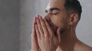 Arap, Hintli, sakallı, çıplak erkek, saçını şampuanla yıkar, saçını ve sakalını yıkar. Spor salonunu kapattıktan sonra otelde duş alır. Esmer şampuan ve saç kremi.