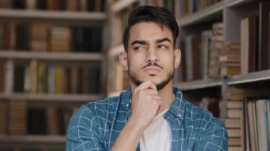 Yakın plan genç, düşünceli, sorunu çözmeyi düşünen bir öğrenci ellerini derin düşüncelere daldırır. Rüyalar, sorular hakkında düşünür. Sınav, cevaplar, gülen çözümler bulur.