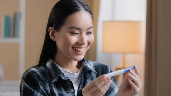 Asian girl pregnant happy girl surprised woman expectant future mother female parent holding looking at positive pregnancy test expecting baby infant childbirth parenthood fertility female gynecology — Stock Photo, Image