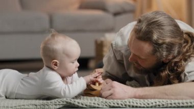 Beyaz aile sakallı baba baba ve küçük kızı bebek yeni doğmuş bebek evde oyuncaklarla oynuyor ahşap inşaatçılar birlikte vakit geçiriyorlar ebeveynlik konsepti oluşturuyorlar.