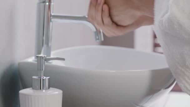Unerkennbarer junger Mann im Bademantel in Großaufnahme Männerhände verwenden Flüssigseife umweltfreundliches Produkt Gel zum Händewaschen wäscht Handflächen zu Hause im Badezimmer im Hotel tägliches Hygiene-Körperpflegekonzept — Stockvideo