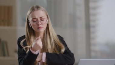 Tasasız iş kadını, gözlüklü kız öğrenci bayan öğrenci, kablosuz kulaklık takıyor favori müzik bandı ses dansını dinliyor dizüstü bilgisayarla masada şarkı söyleyen parmaklarını şaklatıyor.