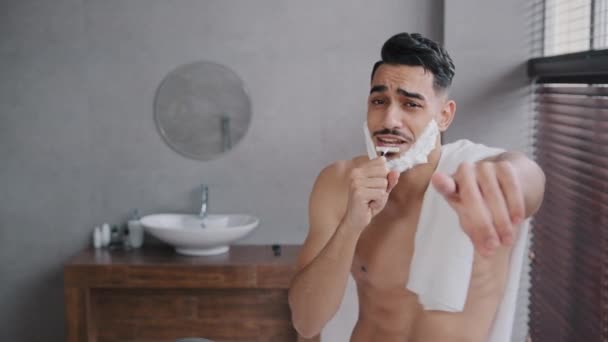 Funny humorous silly happy carefree Arab Indian muscular naked man guy with  white foam shaving gel on beard dances rhythmically moving arms to music  sings having fun dancing in bathroom before shaving —