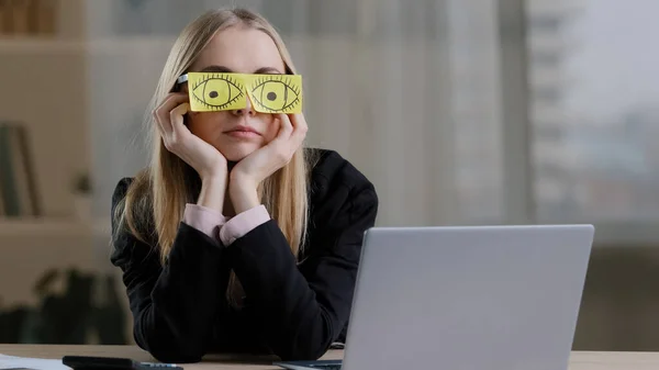 Yorgun, komik, uykulu, tembel, beyaz iş kadını, yapıştırmalı gözlüklü yapışkan notlar. Yorgun kadın işçi işyerinde kestiriyor, masa başında sıkıcı rutin işler yapıyor, uyuyor numarası yapıyor.